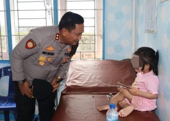 Kapolres Nisel AKBP Ferry Mulyana saat menjenguk bocah perempuan korban penganiayaan. (Dok. Polres Nisel)