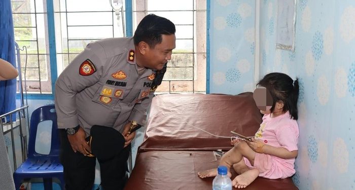 Kapolres Nisel AKBP Ferry Mulyana saat menjenguk bocah perempuan korban penganiayaan. (Dok. Polres Nisel)