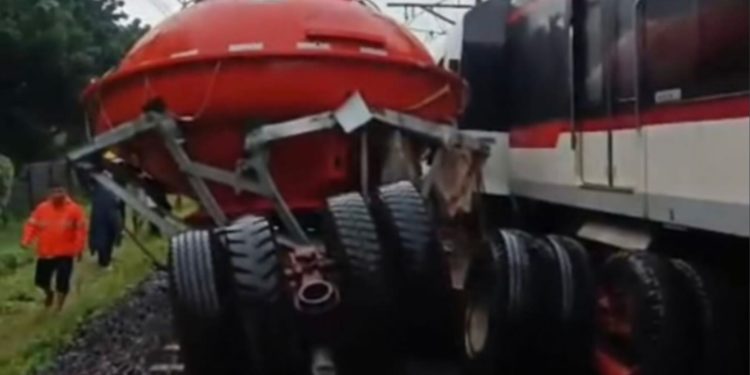 Truk tertemper KA Bandara Soekarno-Hatta di perlintasan Poris Tangerang, operasional kereta ditutup sementara. (dok. istimewa)